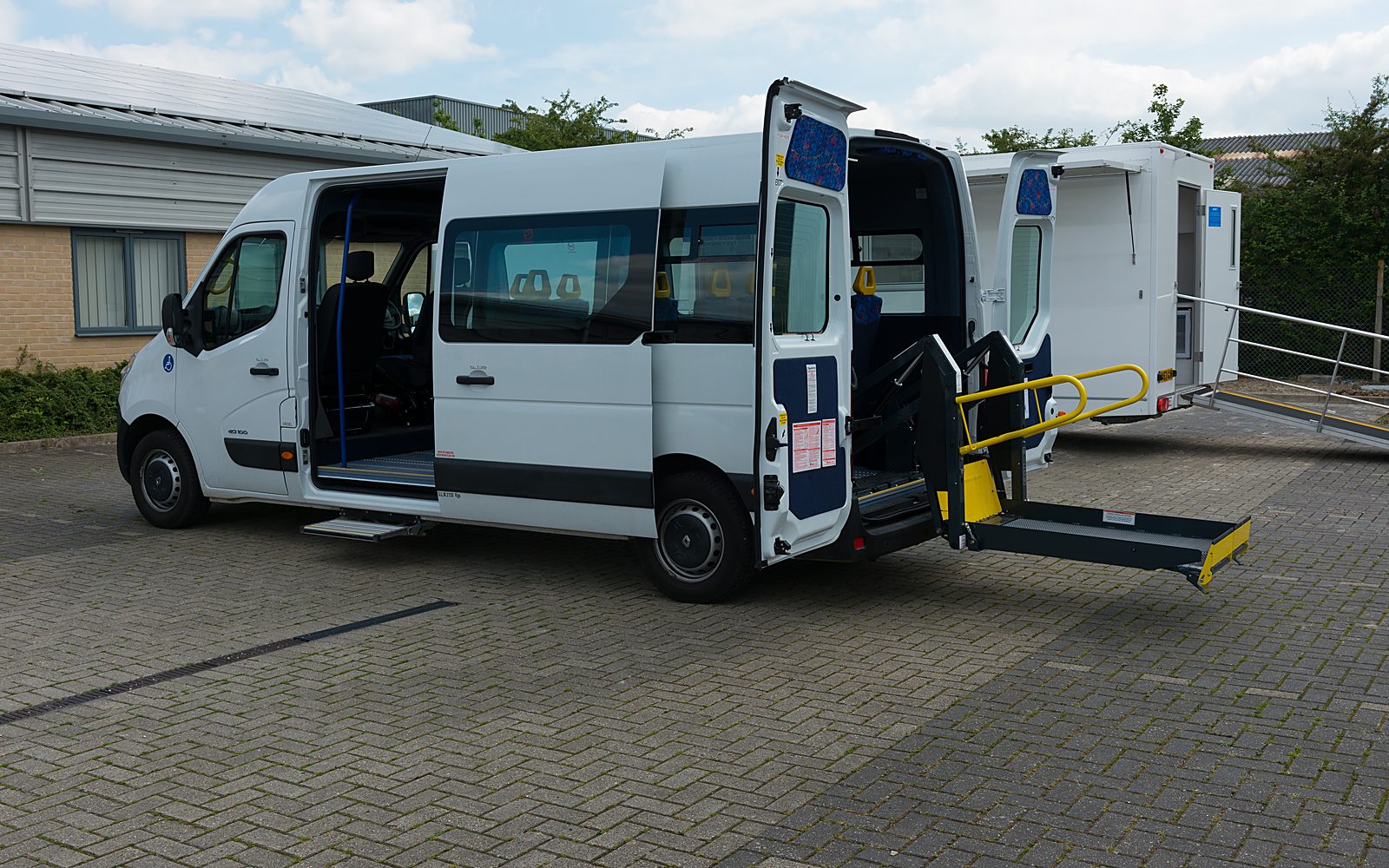 Brand-new accessible 16-seat minibus with side access door and rear wheelchair tail-lift deployed